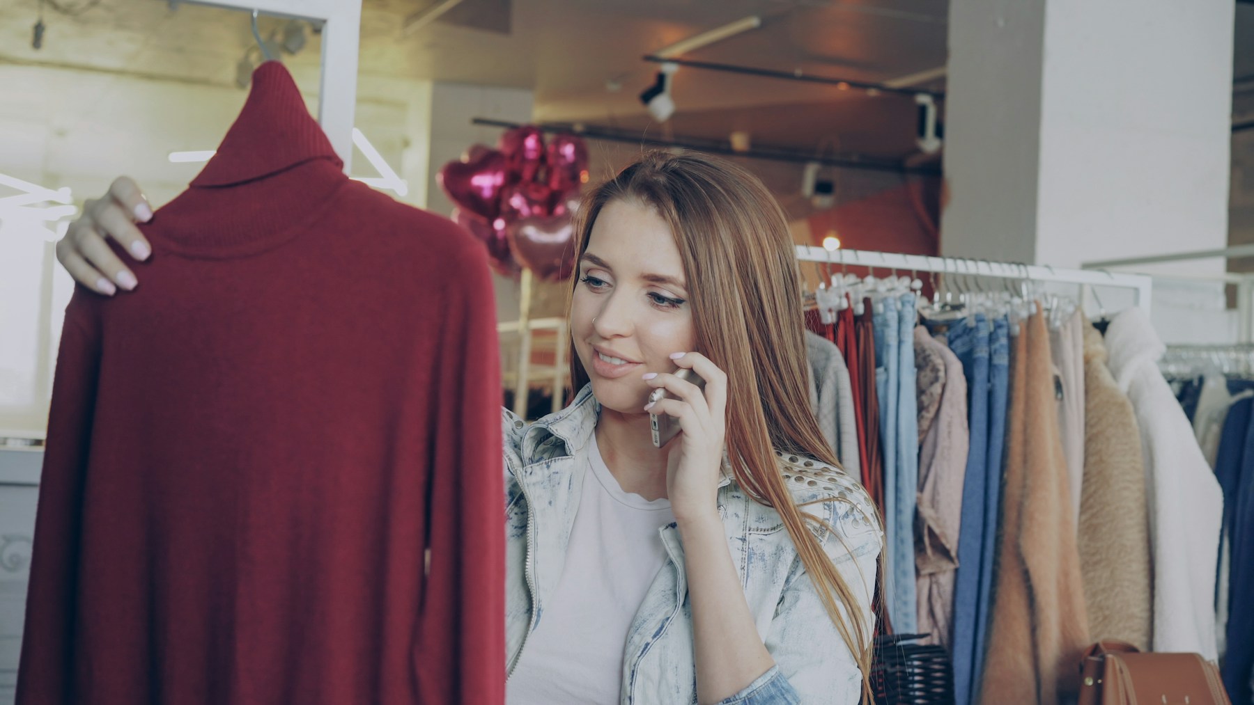 服を選びながらスマートフォンを使う顧客（イメージ写真・and STの店舗や会員ではありません）