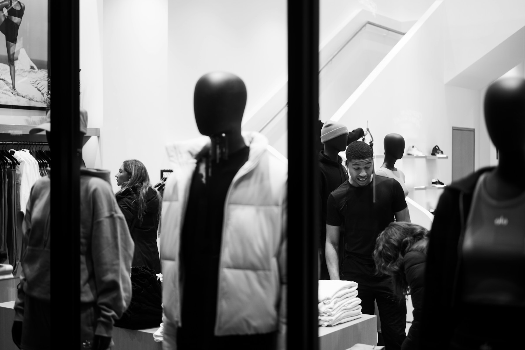 ショップウィンドウと服を選ぶ人々（イメージ写真・ワールドの店舗ではありません）